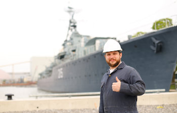 marine chief mate standing near big vessel in background